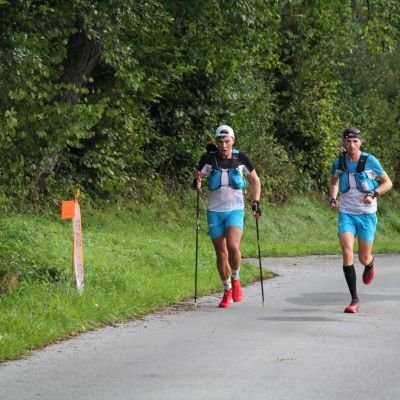 Kurz nach V1 verläuft der Weg einige KM auf Asphalt. Thomas Farbmacher​ und David Wallmann​ wirken fokussiert.