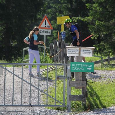 Antonia öffnet Stefan ein Kuhgatter.