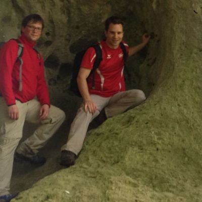Bart und Peter unter einem Kalksteinbogen.
