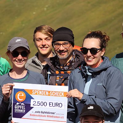 Juli 2023: 6. exito AlpenCross Etappe. Svenja und Alina halten den Spendenscheck.