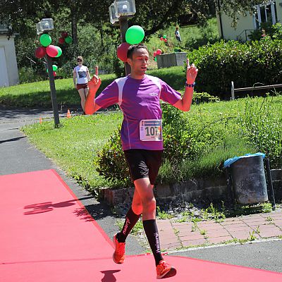 Frankenweg-Lauf 2017: Janek Binzen auf dem roten Teppich am Bildungshaus Obertrubach. Er gewinnt den Halbmarathon beim Frankenweg-Lauf in 1:39:08.
